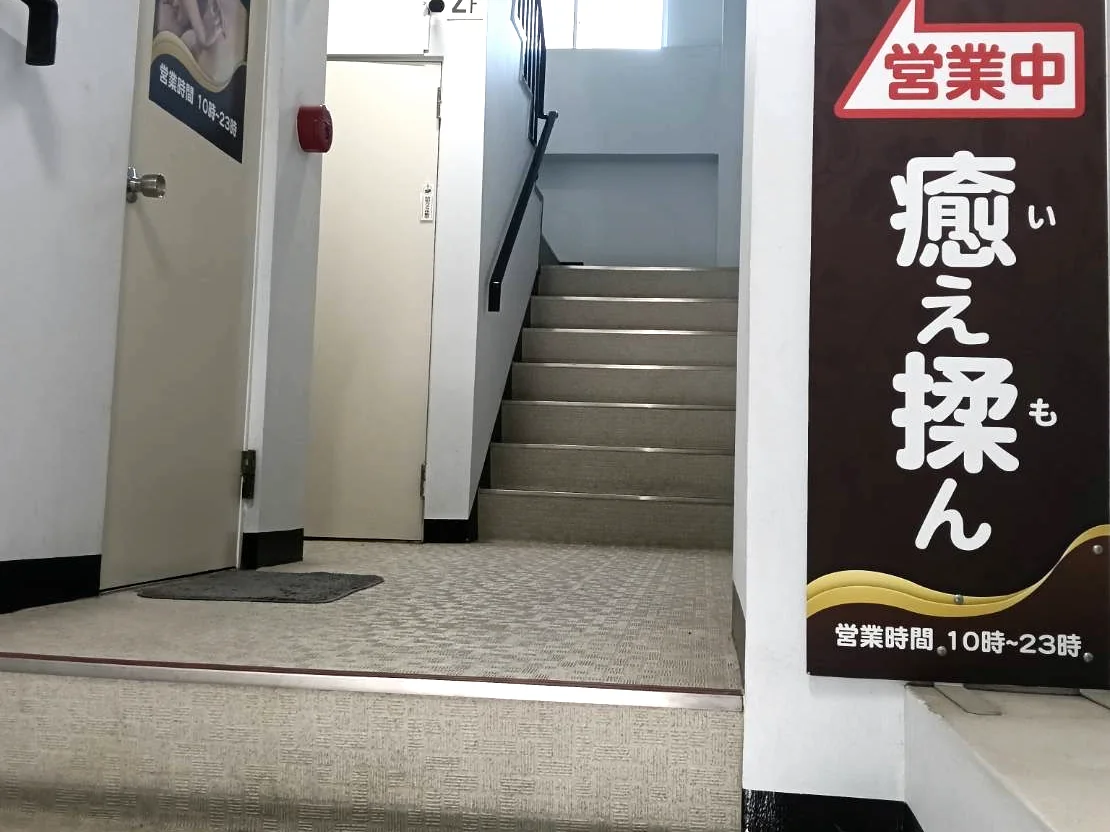 ビル1階から2階の店舗へ上がる階段と営業中の看板